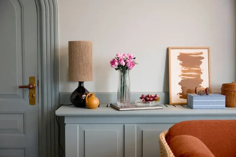 Roses in vase, living room setting.