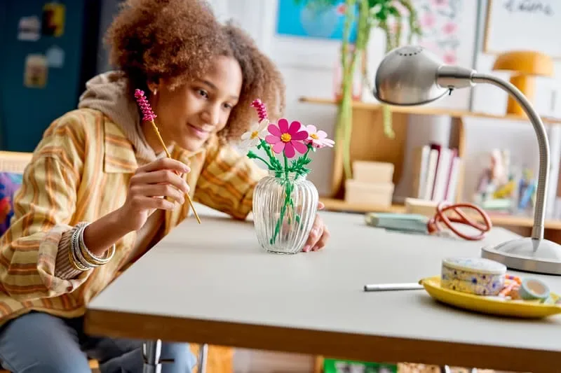 Girl arranging Lego Cosmos Flowers.