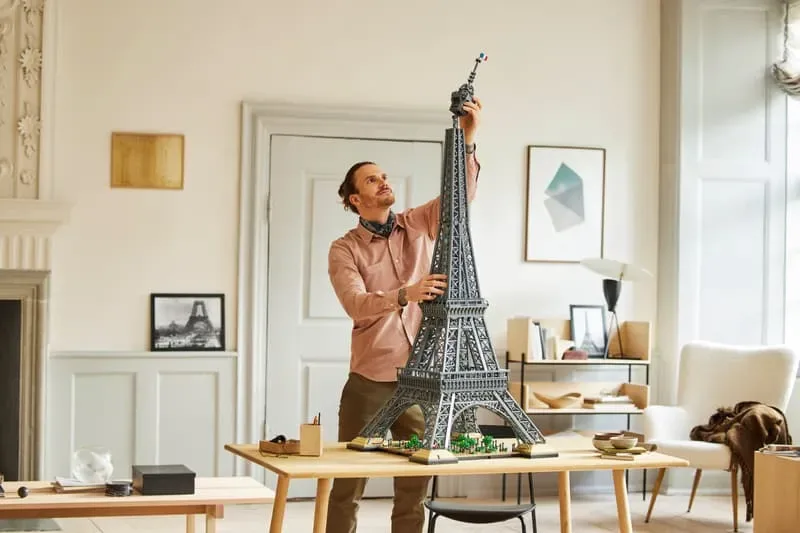 Man assembling LEGO Eiffel Tower.