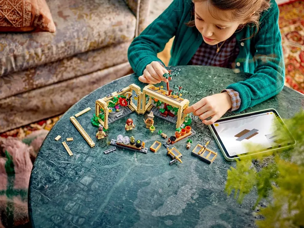 Child playing with set and digital instructions.