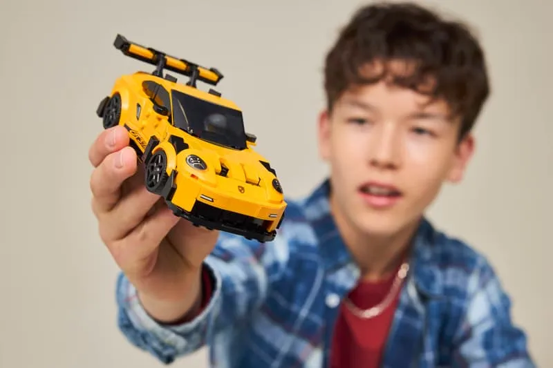 Young person holding the Lego Porsche 911 GT3 RS car, showing its size in hand.