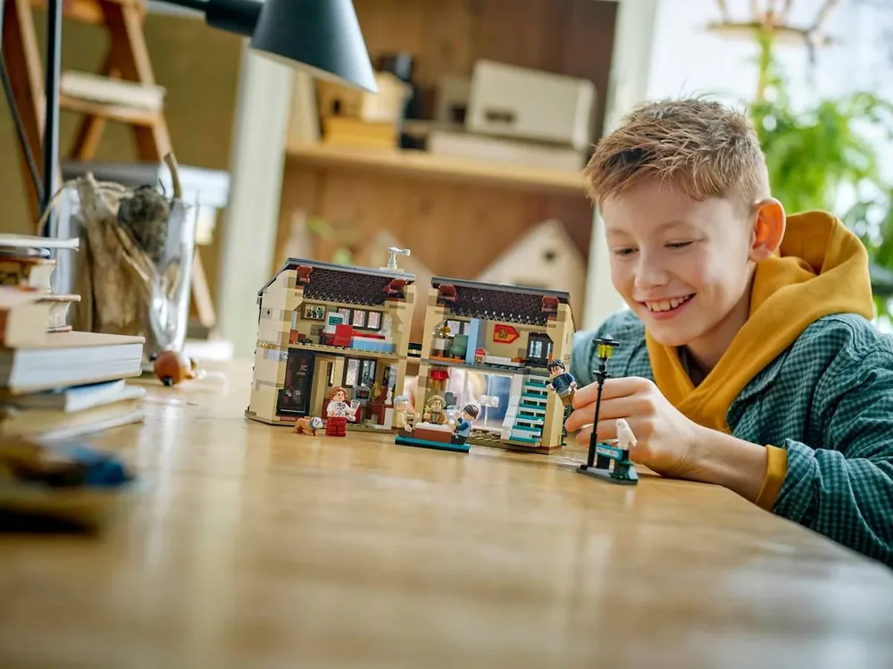 Child playing with closed LEGO Privet Drive.