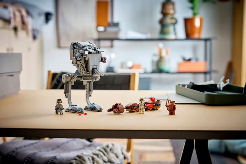 The complete Lego SMART Play AT-ST Attack on Endor 75424 set displayed on a wooden table in a room setting, showing the AT-ST walker, speeder bike, and minifigures.