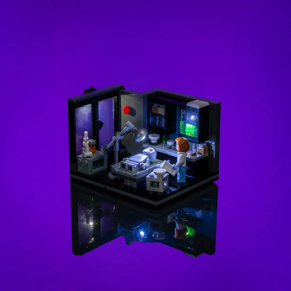 LightMyBricks LED kit illuminating Scully's Lab LEGO set with a warm glow on the desk and equipment