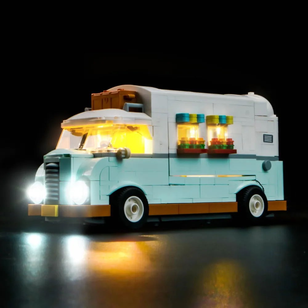 BrickBling LED light kit installed on LEGO Friends Friendship Camper Van Adventure 42663, illuminating the interior living area and picnic table.