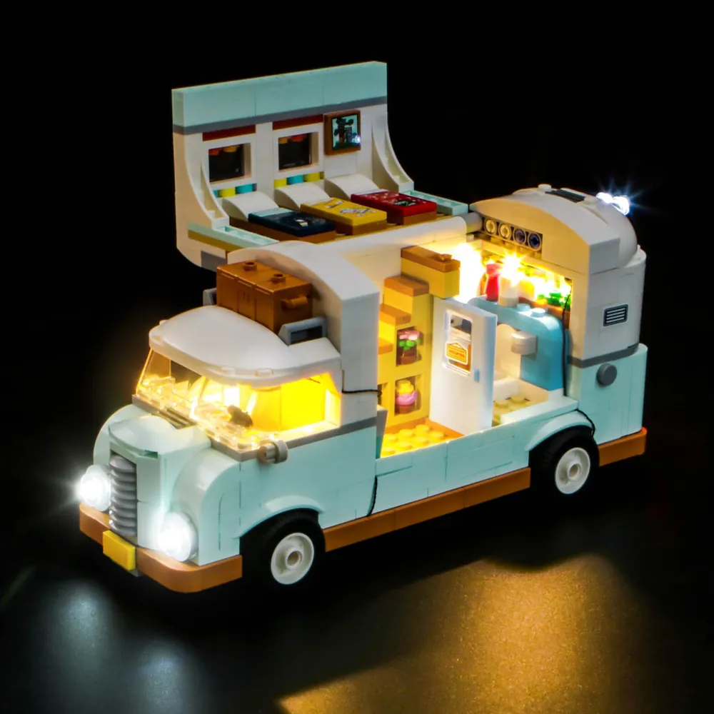 LEGO Friends 42663 with BrickBling lighting fully activated, showcasing a warm glow from the pop-top camper and campsite.