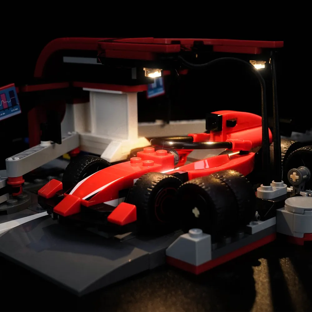 LEGO F1 Pit Stop with BrickBling lights in a dark display