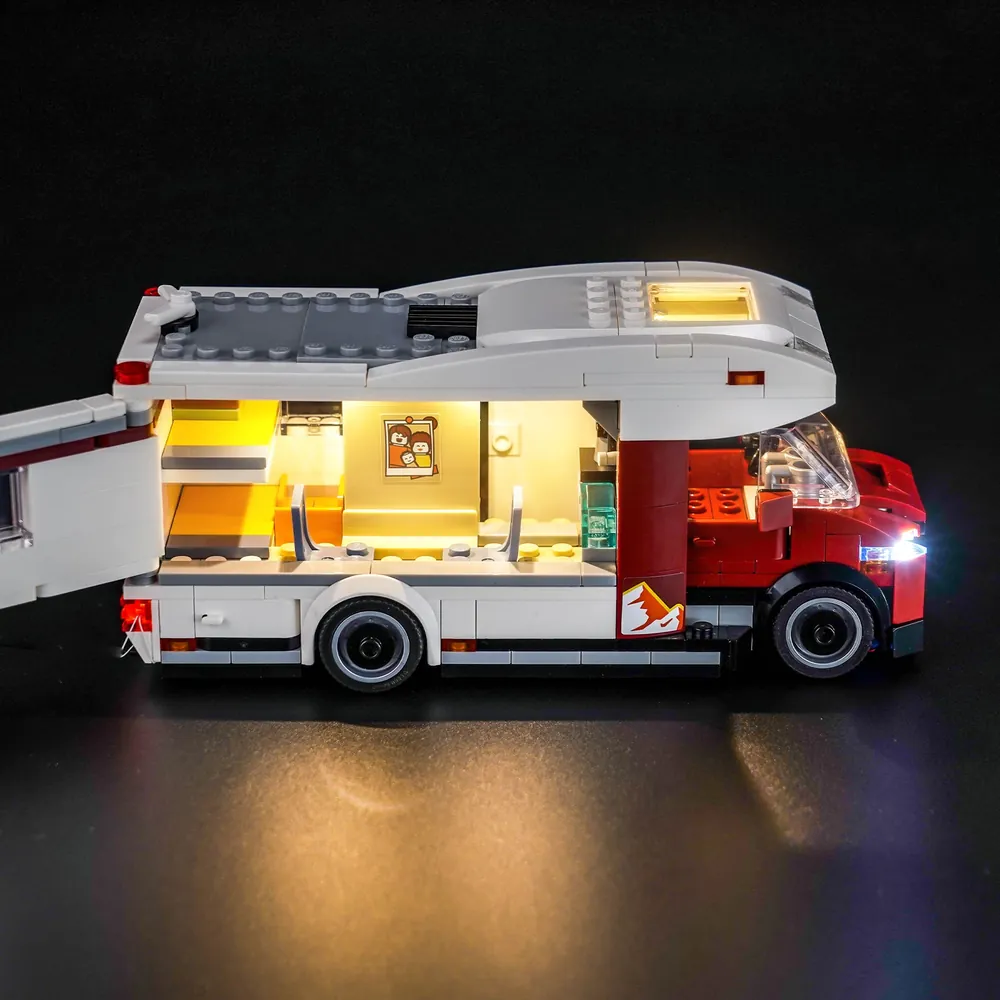 The LEGO Holiday Adventure Camper Van at dusk with BrickBling lights showing the kitchenette and bunk area
