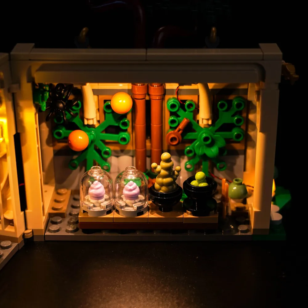 LEGO Hogwarts Herbology Class 76445 with BrickBling lights glowing from the greenhouse's translucent roof panels