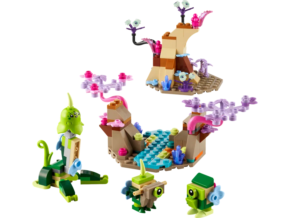 An overhead view of the LEGO 40716 Alien Planet Habitat set, showcasing all its modular components: a towering rock formation, a flowing stream section, and three distinct alien creatures made from various green, teal, and pink elements.