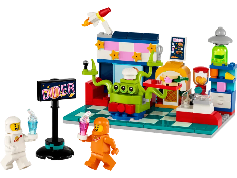 LEGO Alien Space Diner set 40687 featuring a green alien chef, two astronaut minifigures (one white, one orange), and a colorful diner build with a rocket on top. The diner has a striped facade, stars, and a menu sign.