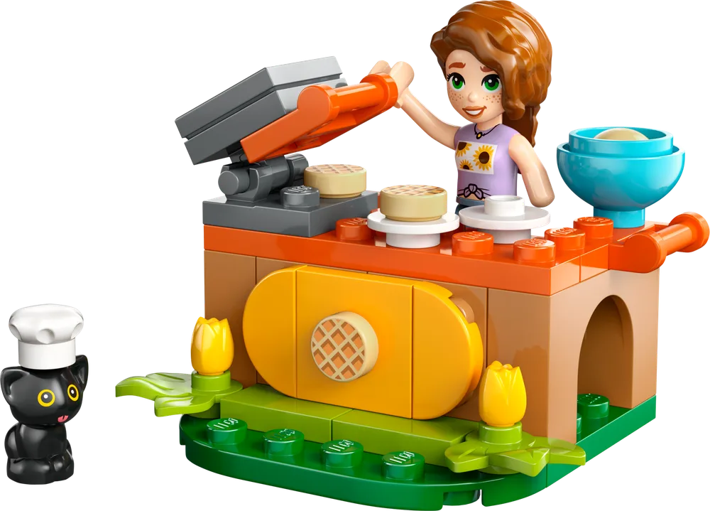 Autumn minifigure serving waffles from a detailed brick-built waffle stand with a chef hat-wearing black cat.