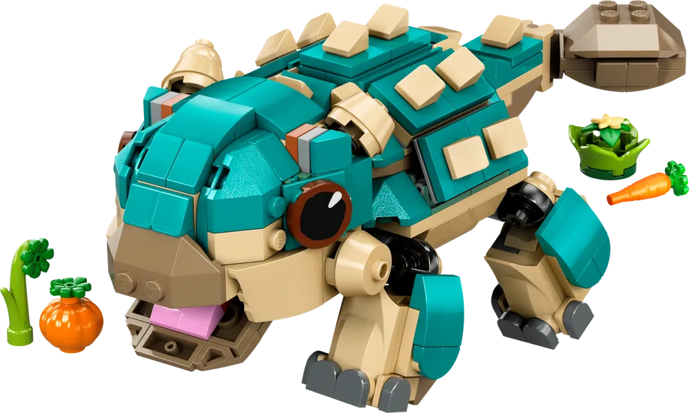 A LEGO build of Baby Bumpy, an Ankylosaurus from Jurassic World, in teal and tan, with articulated legs and tail, and small accessory food builds like a carrot and pumpkin.