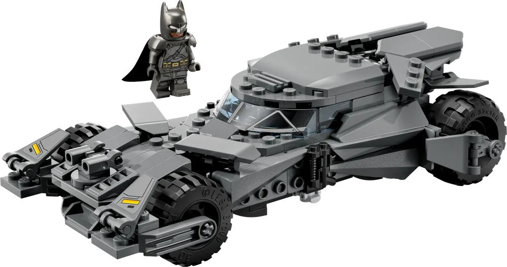 The dark grey LEGO Batmobile from Batman v Superman: Dawn of Justice, with its rugged, armored design and exposed studs, is positioned next to an Armored Batman minifigure.