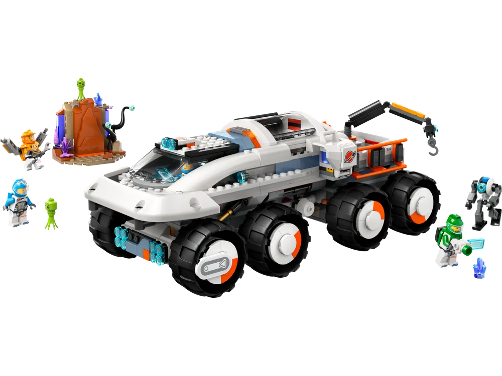 A wide shot of the LEGO City Space Command Rover and Crane Loader set 60432 on a white background. The large white and grey six-wheeled rover with orange accents is central, flanked by three astronauts, two small green aliens, and a small brown and purple alien rock formation.