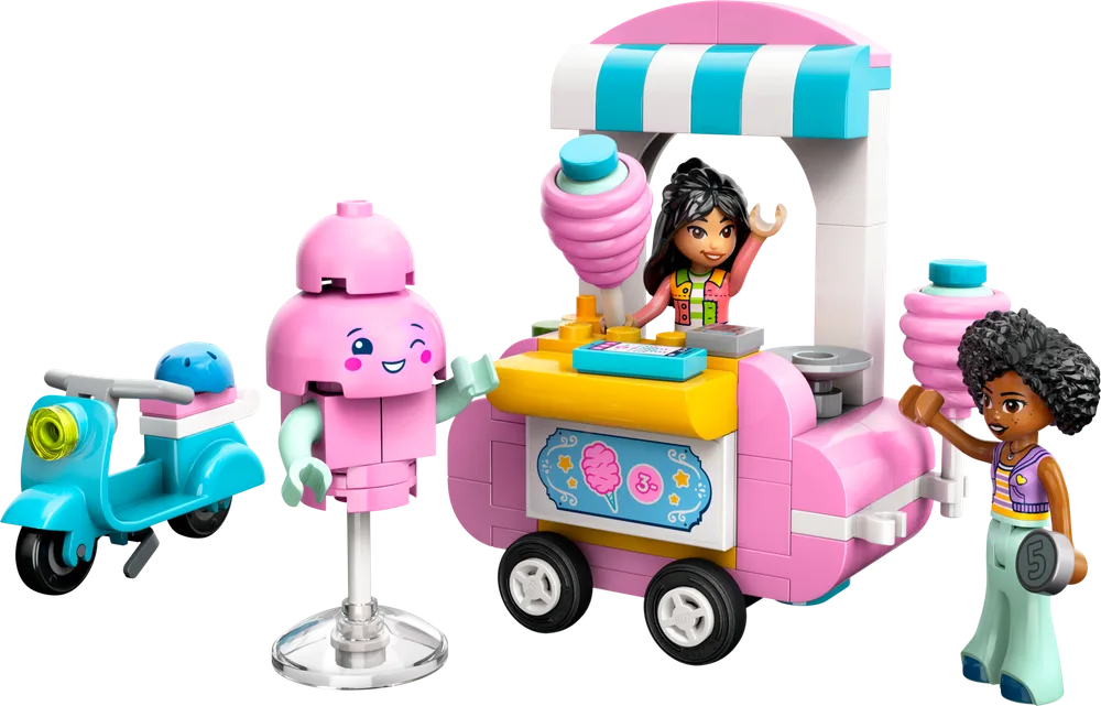 Liann operates the pink cotton candy stand, while Jamila gestures to the friendly cotton candy mascot, with a blue scooter nearby.