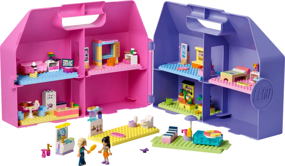 Two open LEGO Friends dollhouse suitcases, one pink and one purple, filled with miniature furniture and accessories. Two minifigures stand outside with additional loose accessories.