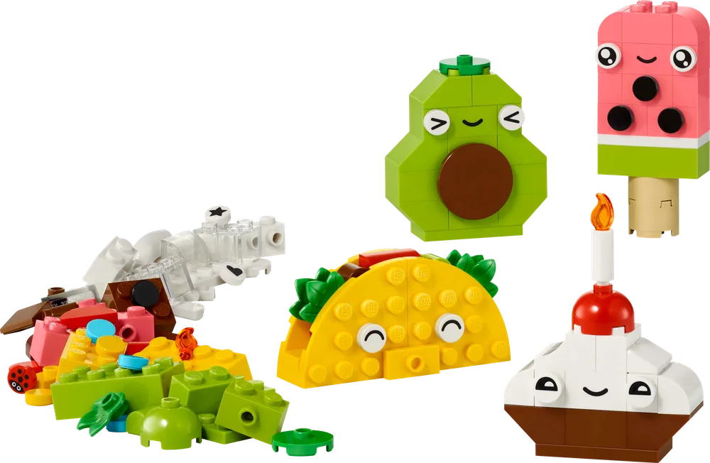 An assortment of LEGO food models including a taco, avocado, cupcake, and popsicle, with loose bricks beside them.
