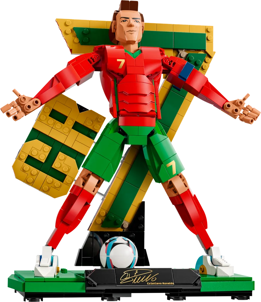 LEGO build of Cristiano Ronaldo in his signature 'Siii' celebration pose, featuring red and green kit with a large yellow and green 'CR7' backdrop. A LEGO football is at his feet on a green base.