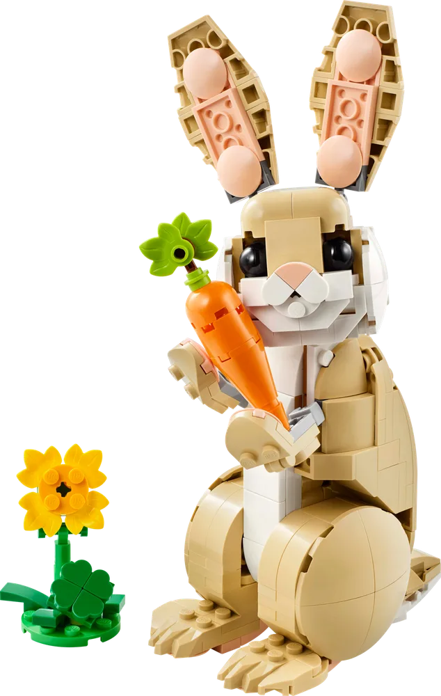 A tan LEGO bunny stands upright, holding an orange carrot with green leaves in its paws, next to a yellow flower on green base.