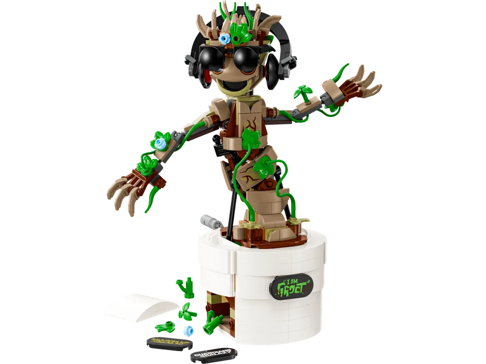 Full view of the LEGO Marvel Dancing Groot, set 76297, wearing headphones and sunglasses, in a dynamic pose within its white pot, with extra leaf elements scattered below.