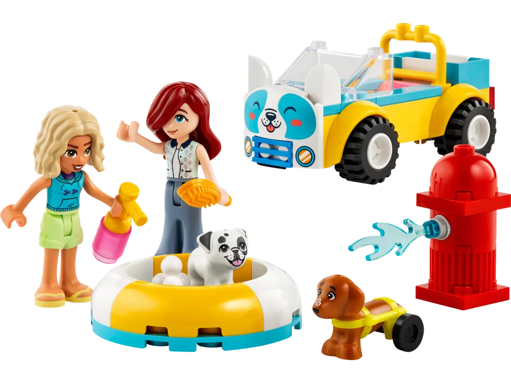 All components of the LEGO Friends Dog-Grooming Car set laid out: a yellow and blue car with a dog face on the front, two LEGO Friends minifigures (Nova and Paisley), a pug in a white and yellow bathtub, a brown dachshund on wheels, a red fire hydrant with a light blue 'water' element, a pink shampoo bottle, and an orange brush.