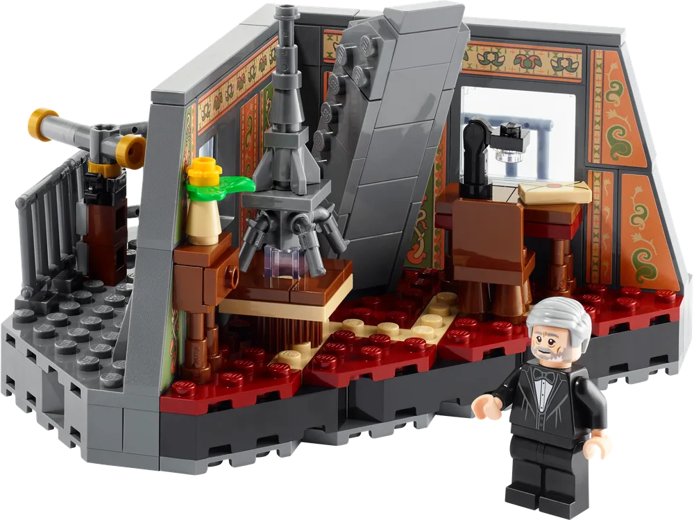 A detailed close-up of the LEGO Eiffel's Apartment set, showing the interior with a tiled floor, ornate walls, a desk with a lamp, a miniature Eiffel Tower, and a balcony with a telescope. The Gustave Eiffel minifigure stands in front of the set.