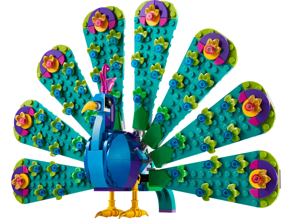 A vibrant LEGO peacock model with its tail fully fanned out, showcasing colorful eye spots and a blue body, against a white background.