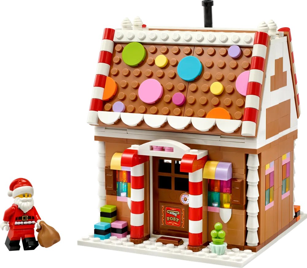 Full front view of the LEGO Gingerbread House 40809 with Santa minifigure, featuring brown walls, white frosting details, a colorful candy-covered roof, and red and white candy cane pillars.