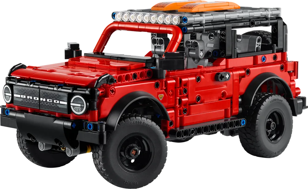 LEGO Technic Ford Bronco SUV in bright red with roof rack and detailed front grille, angled to show its rugged design.
