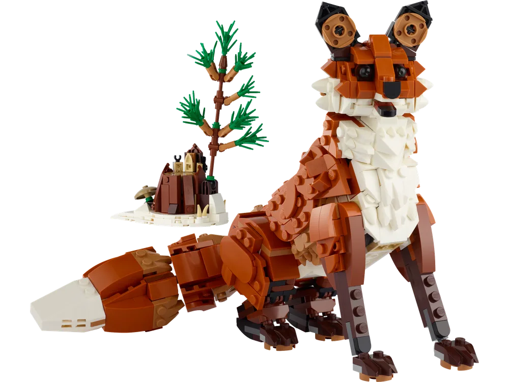 A LEGO brick-built fox sits majestically, with a small brown tree and snowy base behind it.