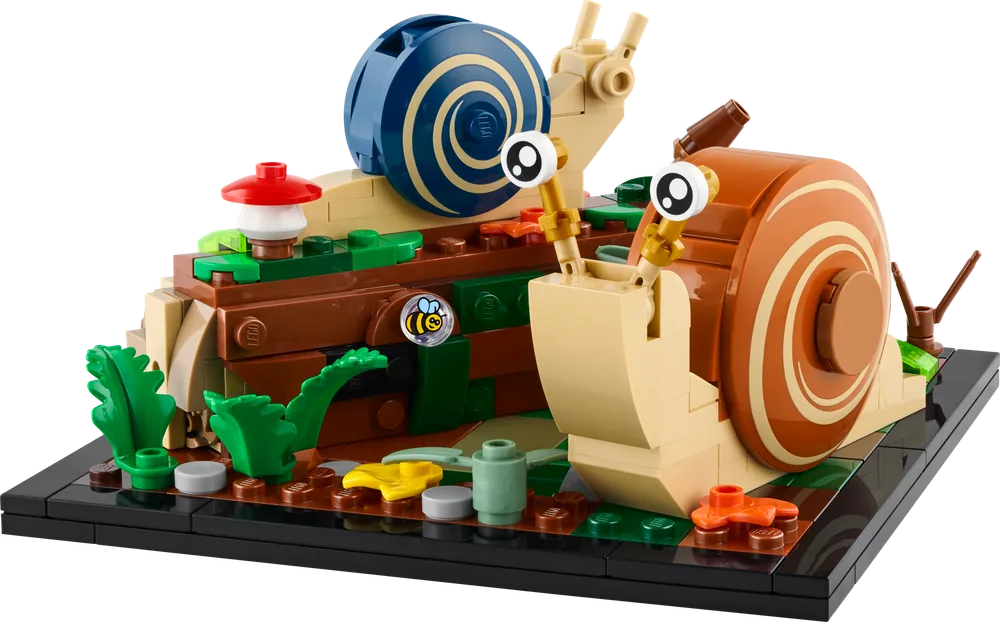 Two LEGO snails, one large brown and one smaller blue, are positioned on a brown log base with green foliage and a red mushroom.