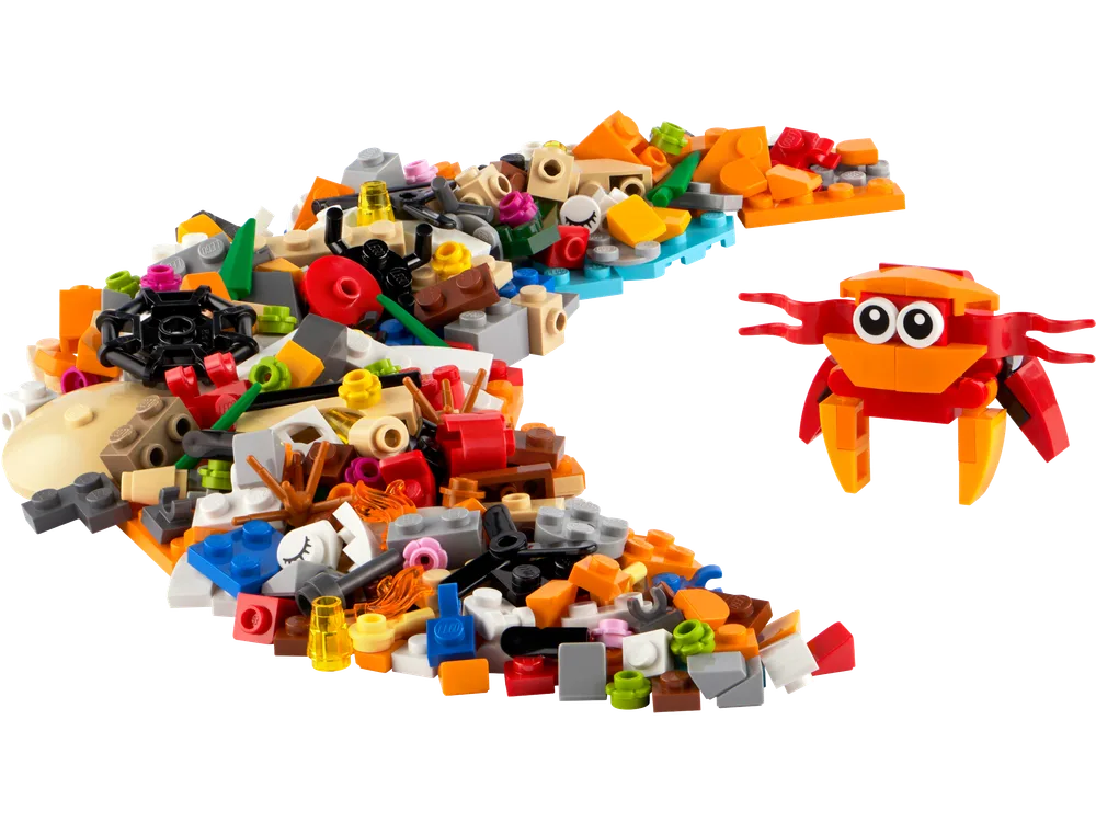 A pile of diverse LEGO bricks, with a small red and orange crab creature built next to it on a white background.