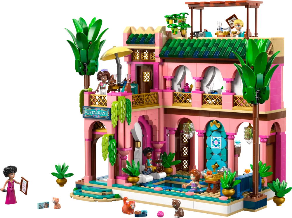 Front view of the LEGO Friends Garden Restaurant set, showcasing its pink and teal multi-story building with lush palm trees, an outdoor pool, and minifigures enjoying the various areas.