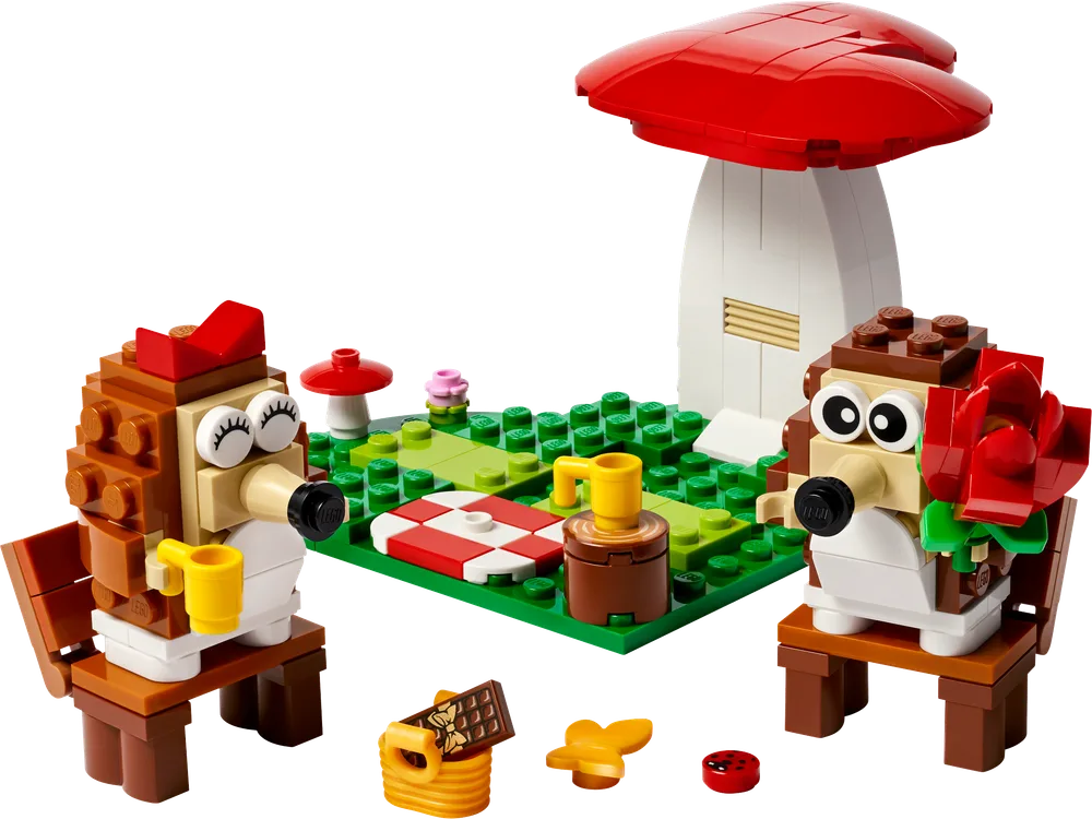 The assembled LEGO 40711 Hedgehog Picnic Date set, featuring two brick-built hedgehogs, a red and white checkered blanket, a tall red mushroom, and various picnic accessories on a green baseplate.