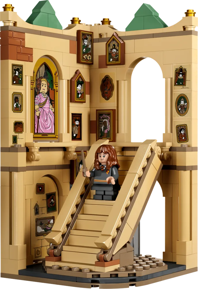 Hermione Granger stands on a rotating staircase in a tan brick Hogwarts tower, surrounded by many framed portraits.