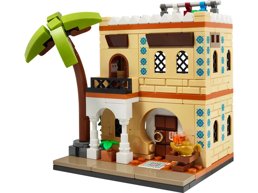 Front view of the LEGO 40590 Houses of the World 2 set, a tan building with a palm tree, featuring ornate windows, a balcony, and a small table with a teapot and cup.