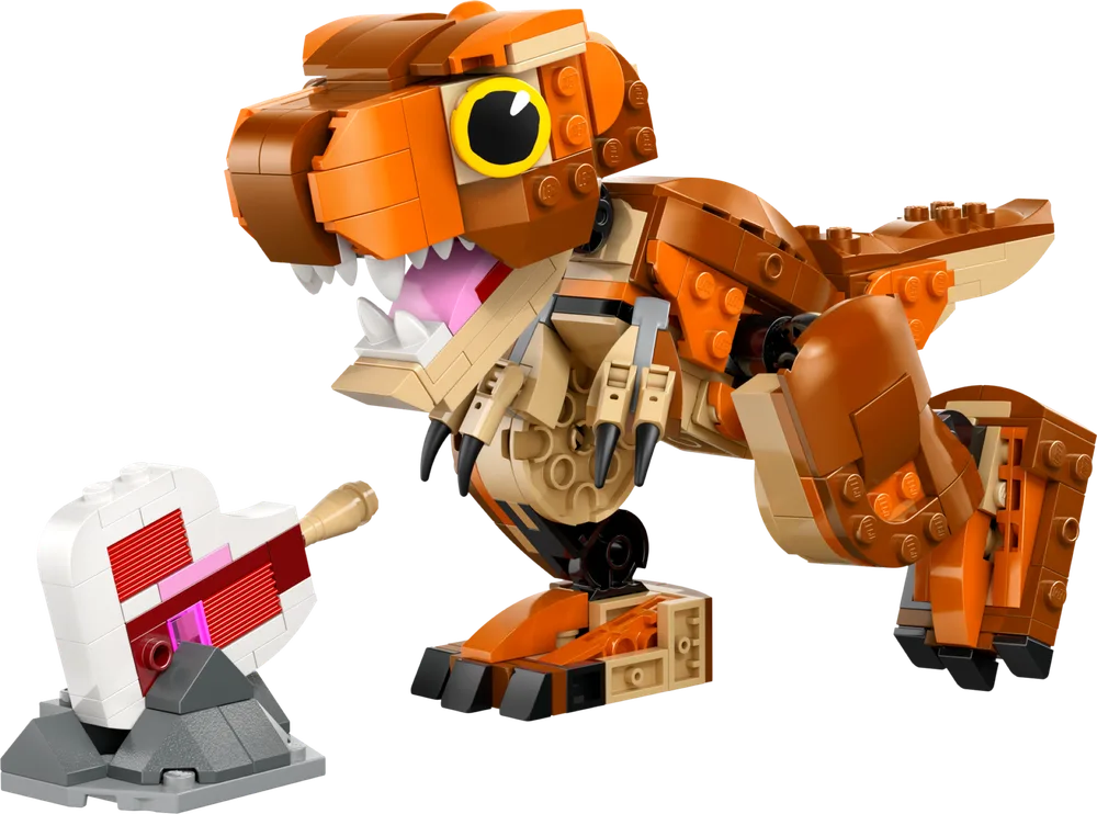 A LEGO Jurassic World Little Eatie T. rex model stands with its mouth open, roaring, next to a small white and red bone or meat accessory. The dinosaur is predominantly orange and tan, with black claws and expressive yellow eyes. The background is pure white.