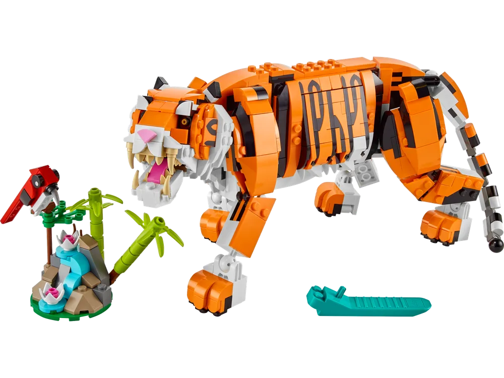 The LEGO Creator 3-in-1 Majestic Tiger set 31129, fully built with a red parrot and bamboo fountain, plus a frog, set against a white background.