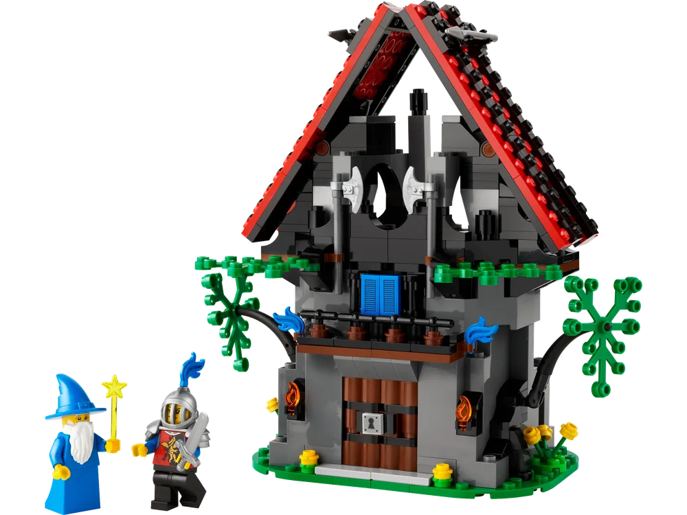 Majisto the wizard and a Black Falcon knight stand in front of Majisto's Magical Workshop, a dark gray and black building with a red roof and green foliage, against a white background.