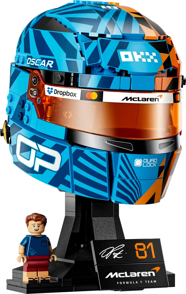 Front view of the LEGO McLaren Mastercard F1 Team Oscar Piastri Helmet model, showcasing its blue and orange livery with a transparent orange visor and a minifigure of Oscar Piastri on the display stand.