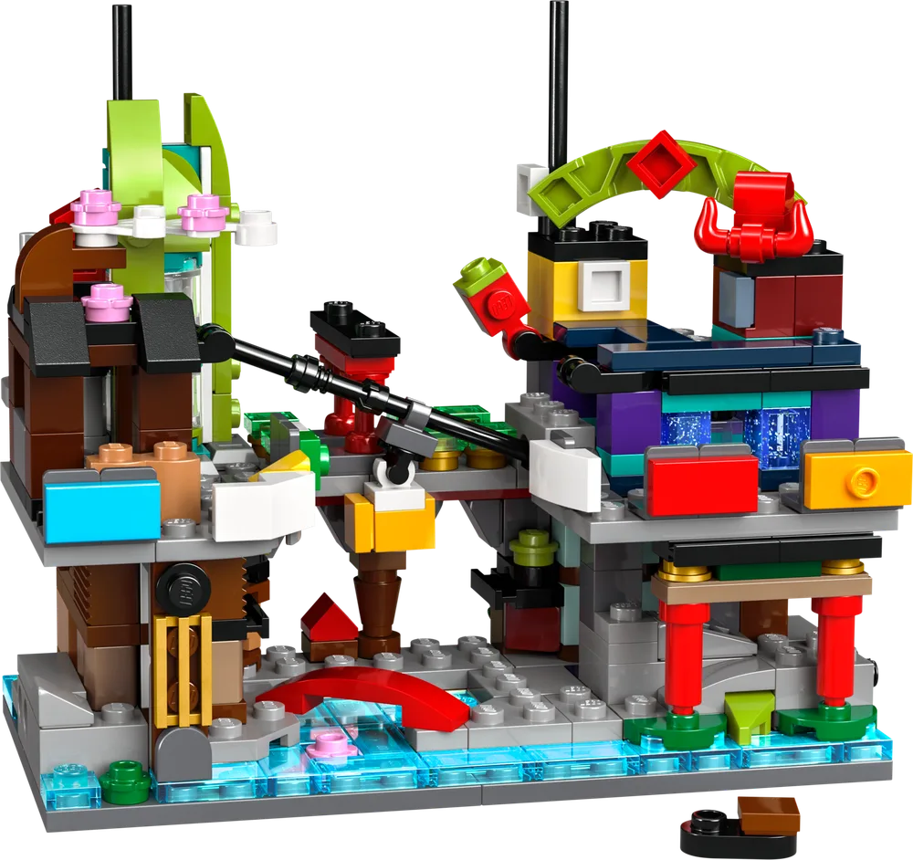 A close-up view of the LEGO 40706 Micro NINJAGO City Markets set, showcasing intricate micro-scale architecture, colorful buildings, and transparent blue elements representing water.