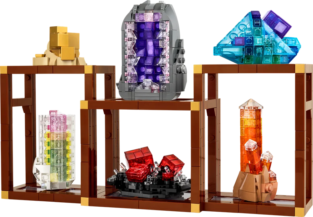 A vibrant display of six LEGO-built mineral specimens on brown modular stands. From left to right: a clear multi-colored crystal, a pile of gold nuggets, a purple geode, red crystals on a black base, a blue angular crystal, and an orange crystal column.