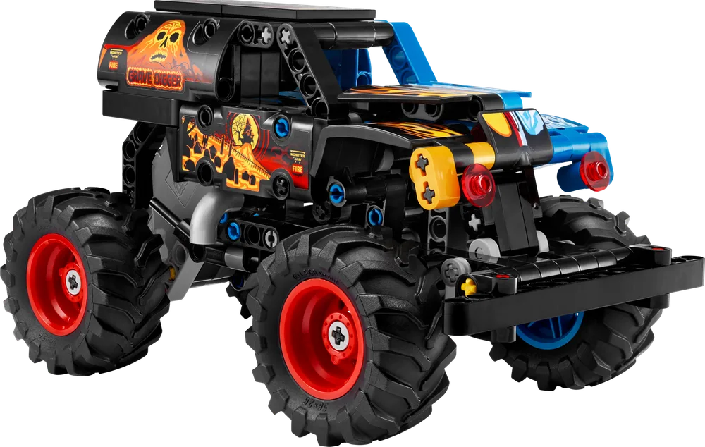 A dynamic, low-angle shot of the LEGO Technic Monster Jam Grave Digger monster truck, with its black body, large off-road tires, and vibrant flame and skull decals in red and yellow. The front grill and suspension elements are clearly visible, showcasing the rugged Technic construction.