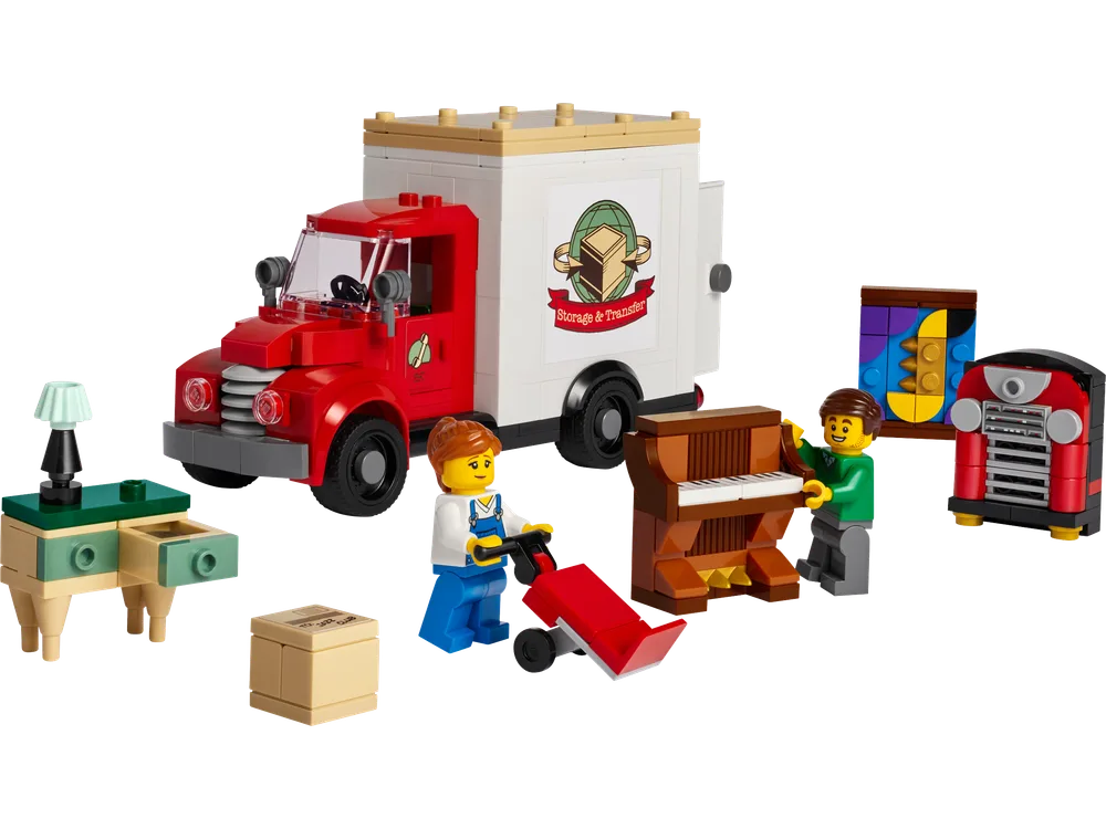 A close-up view of the LEGO Moving Truck set (40586) and its included elements, showing the red and white moving truck, two minifigures, a brown upright piano, a green and tan bedside table with a lamp, a framed painting, a cardboard box, and a red stove or fireplace. All elements are clearly separated on a white background.