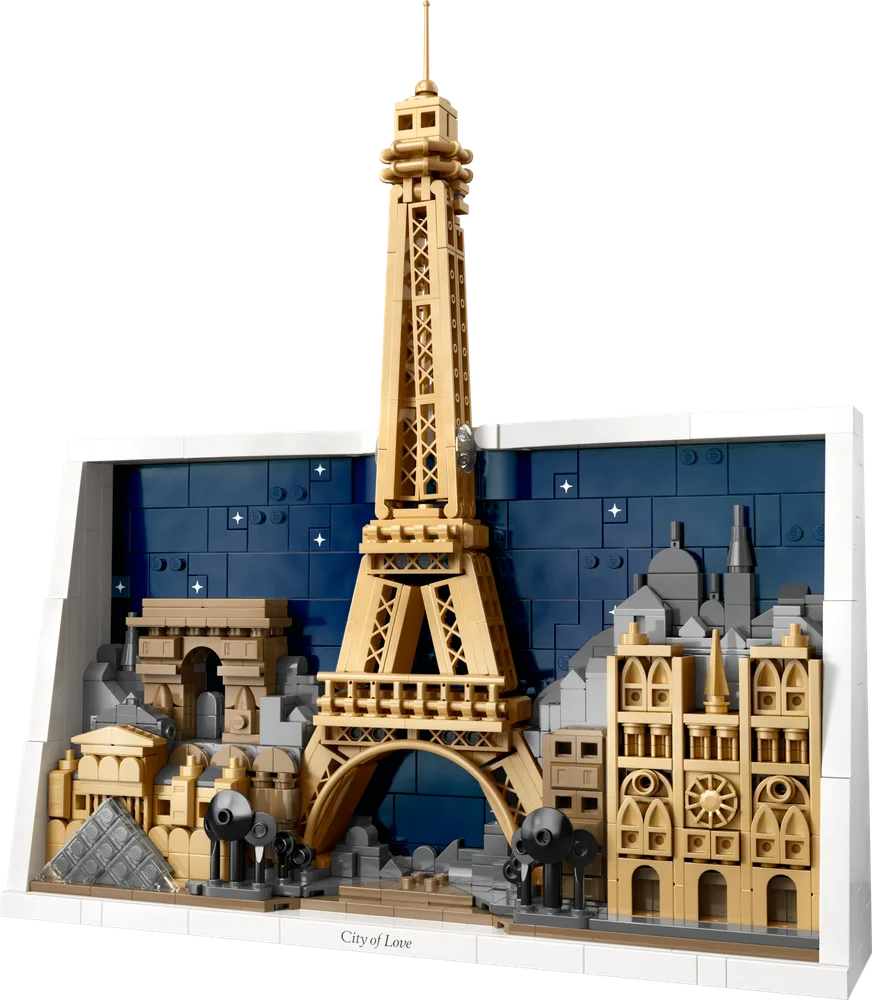 The LEGO Architecture Paris skyline set, featuring the Eiffel Tower, Arc de Triomphe, Louvre Pyramid, and Notre Dame, set against a dark blue background with stars and a white frame.