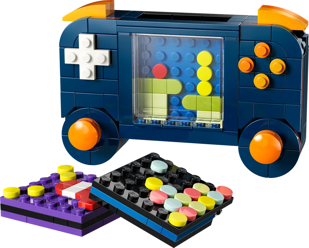 Close-up of the dark blue LEGO Creator 3-in-1 Retro Gaming Console handheld, showcasing its D-pad, circular buttons, trans-clear screen with pixel art, and two game cartridges.