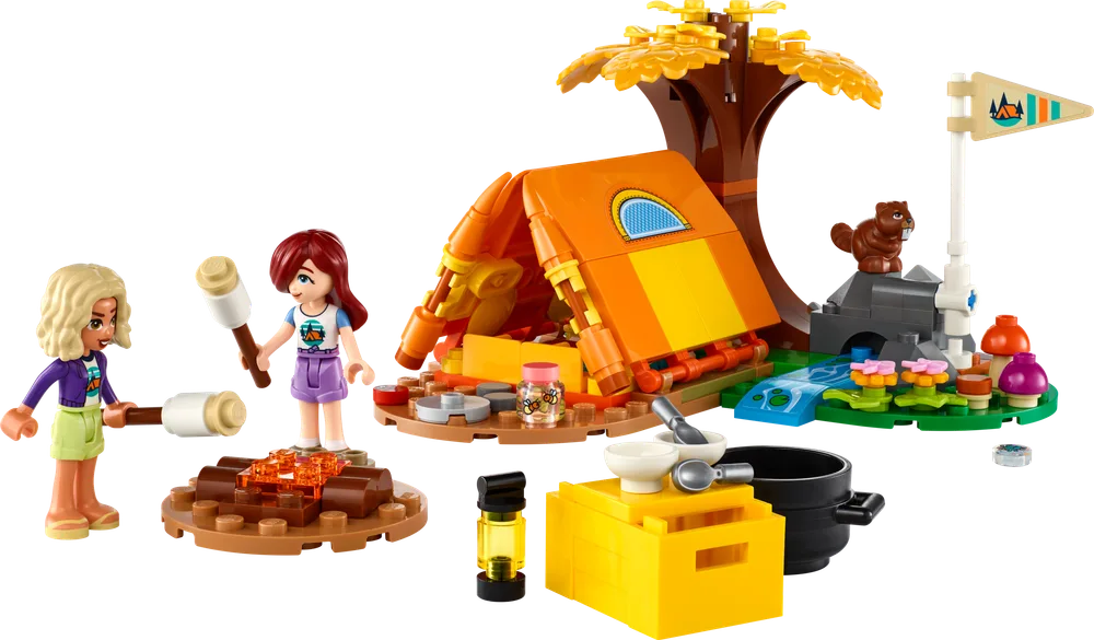 Two LEGO Friends minifigures, Nova and Paisley, toast marshmallows over a brick-built campfire beside an orange tent and a scenic riverbank with a tree and a squirrel.