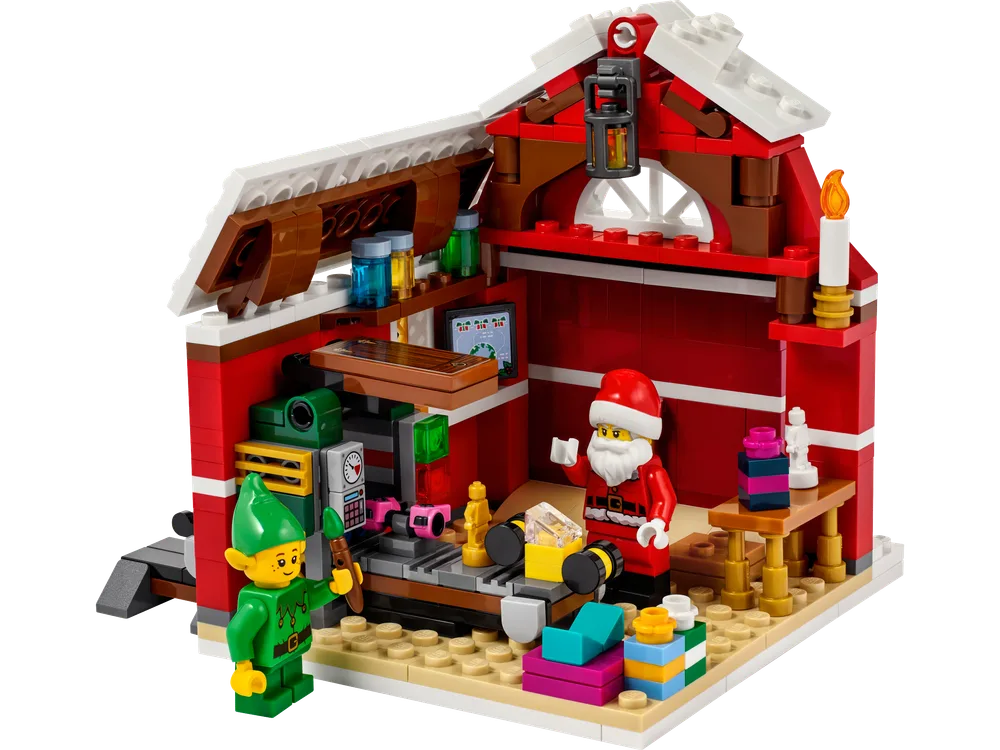 Detailed interior of Santa's workshop featuring Santa and an elf, a toy conveyor belt, and various holiday elements.