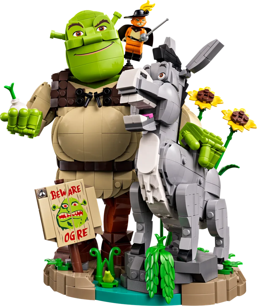 Shrek, Donkey, and Puss in Boots brick-built figures standing on a swampy base with a 'Beware Ogre' sign and sunflowers.